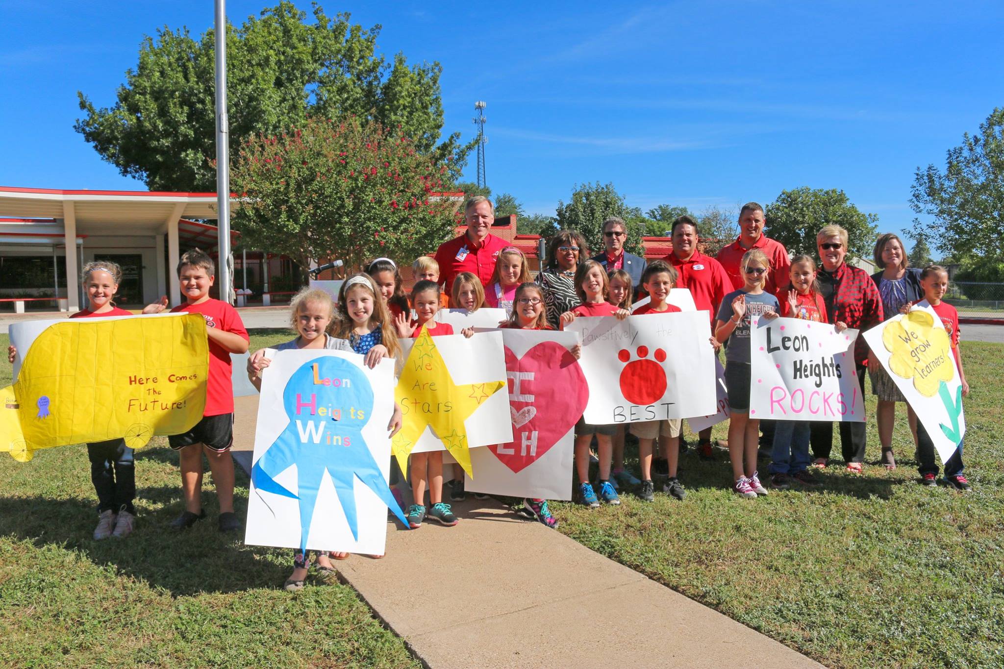 students of Whitney ISD pose with posters at ribbon cutting